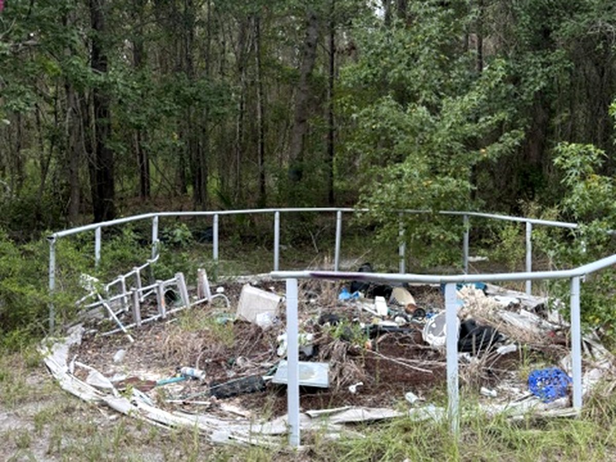 Property piled with junk and debris before Backroad Hauling cleanout